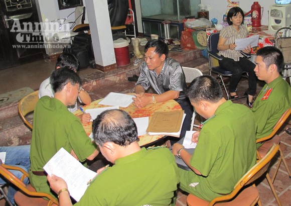 Ông Vinh (áo sẫm, ngồi giữa), chủ cơ sở giết mổ làm việc với Cảnh sát môi trường.